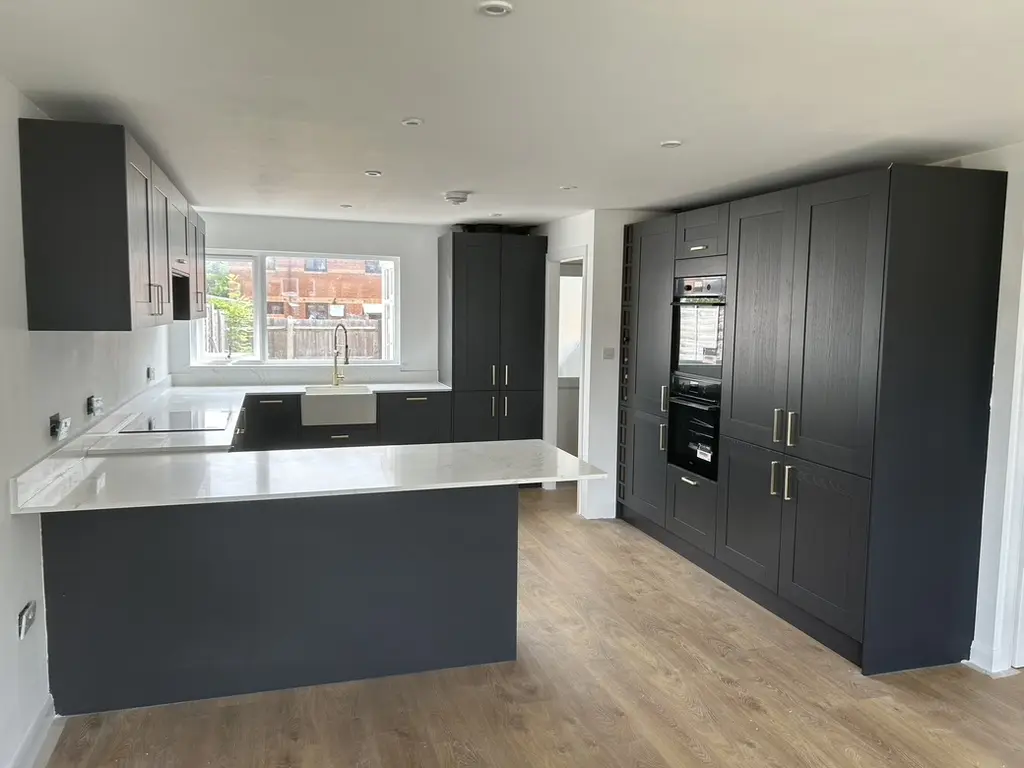 Finished charcoal shaker kitchen with tall units and belfast sink
