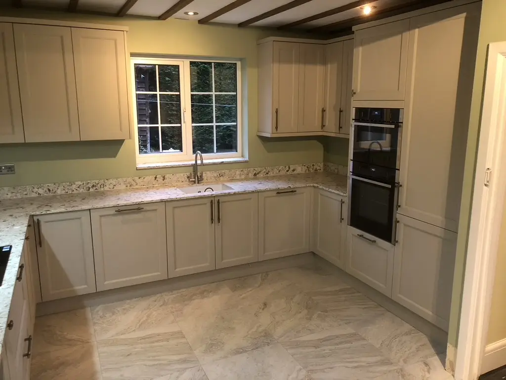 Finished cream shaker kitchen with granite worktops and stone-effect floor tiles