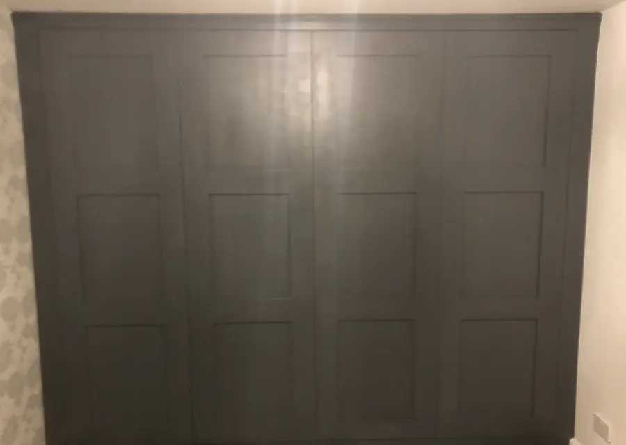 Dark grey four-door shaker fitted wardrobe filling a bedroom wall