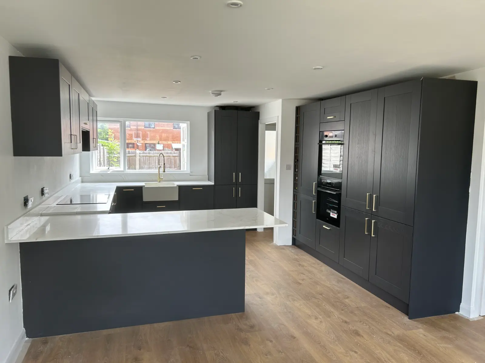 Finished charcoal shaker kitchen with white quartz peninsula