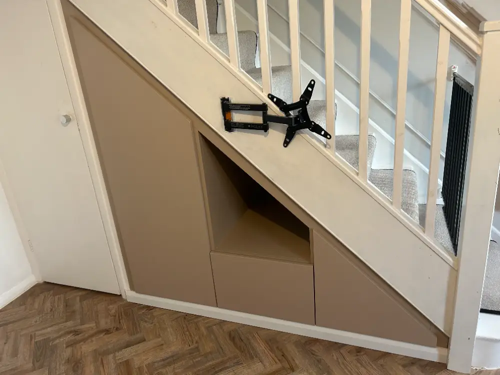 Built-in under-stair storage with flush handleless doors and a deep drawer
