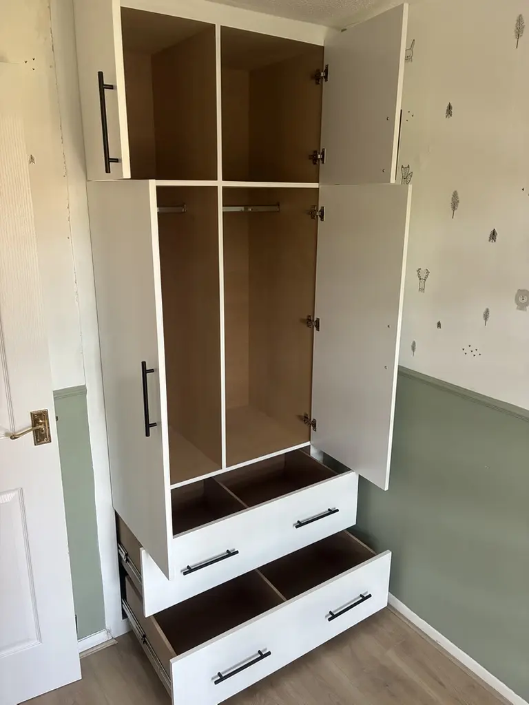 Built-in wardrobe open, showing hanging rails, upper cupboards and divided drawers